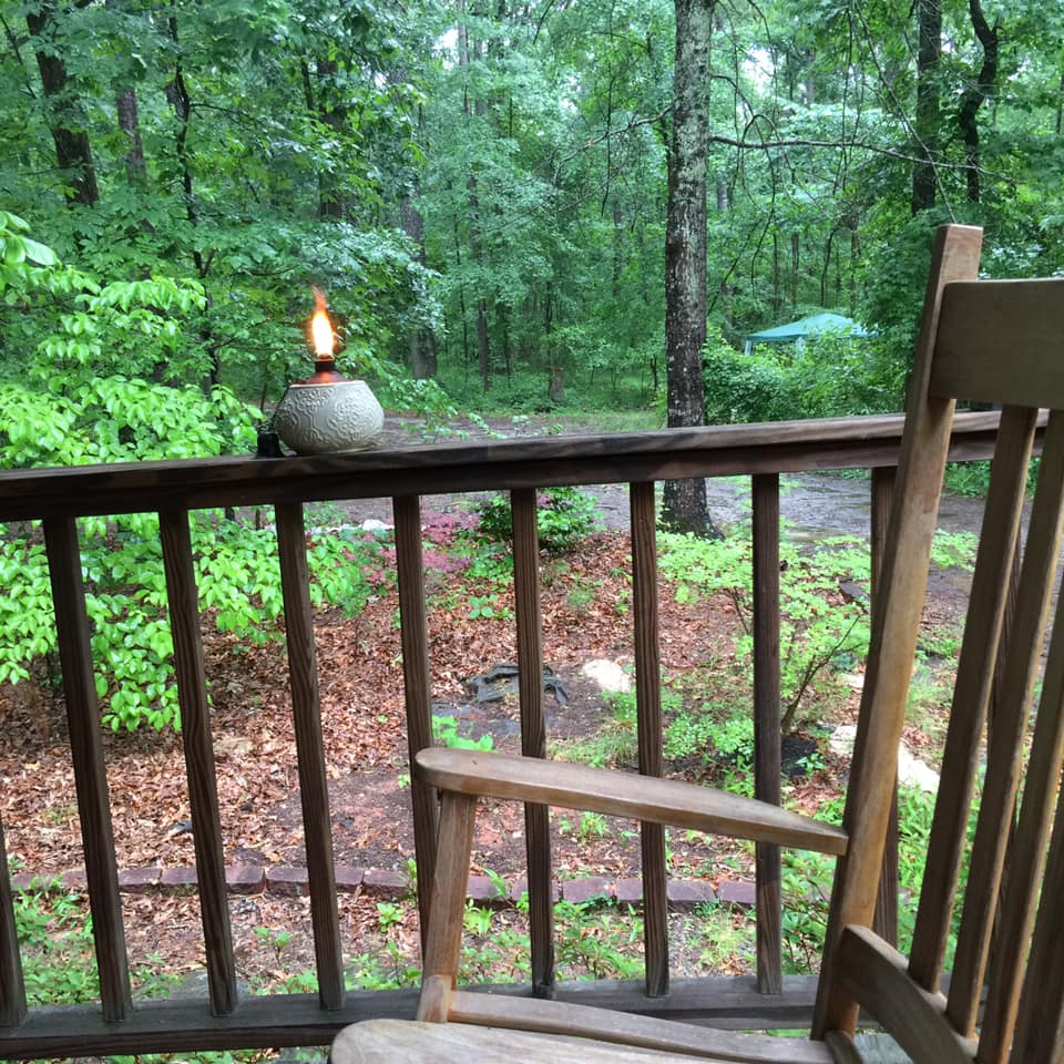 Front porch with rocking chairs after a rain. A citronella candle is lit to scare away the mosquitos.