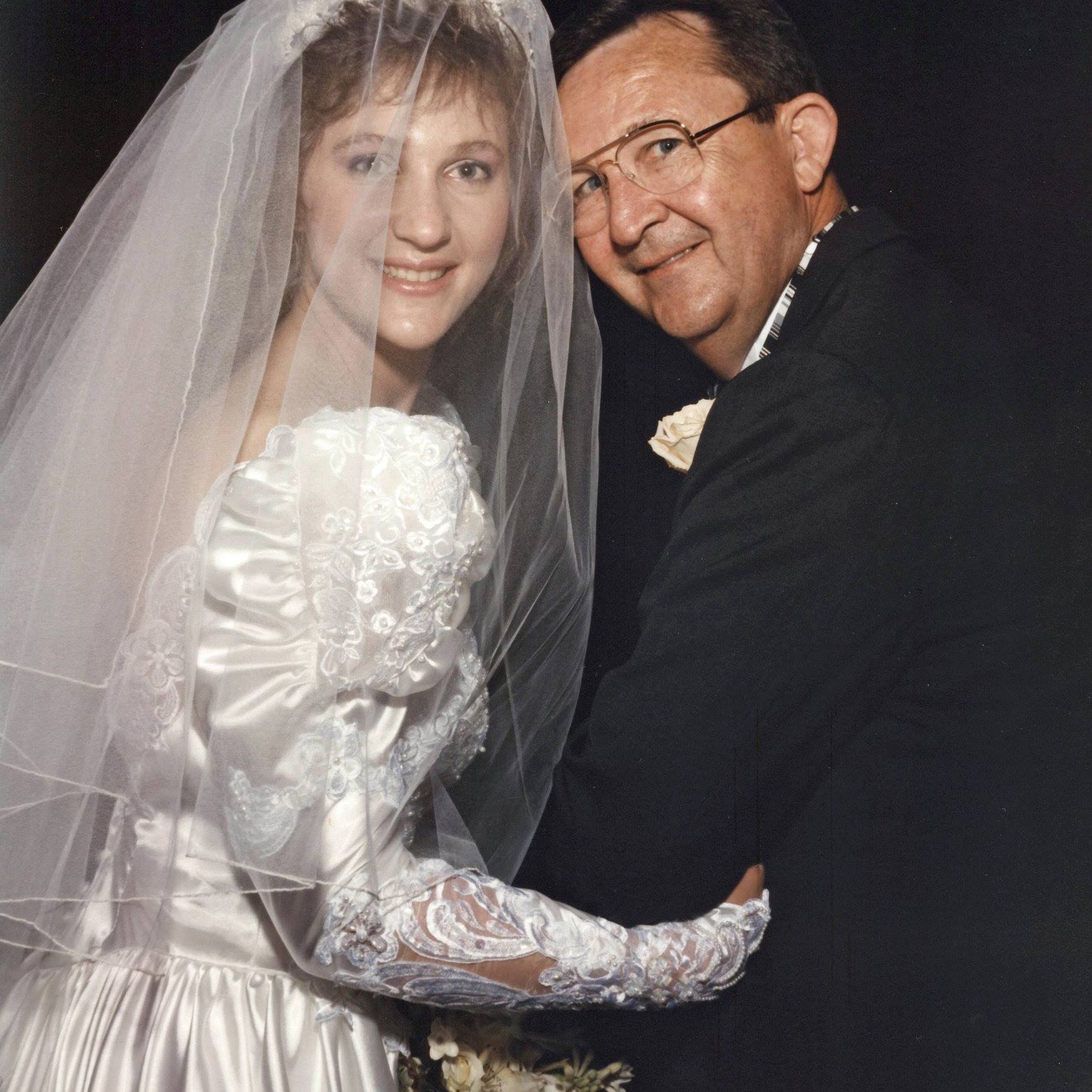 Susanne with her father about to go down the aisle on her wedding day wearing white wedding dress and veil.