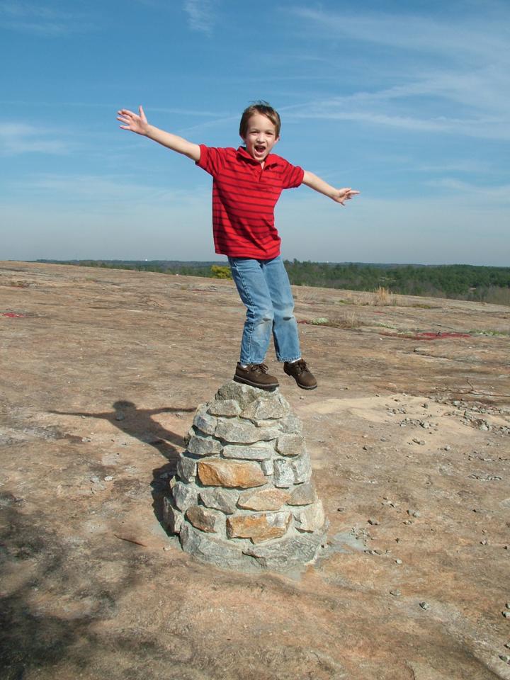 Exuberant young boy on a mountain top