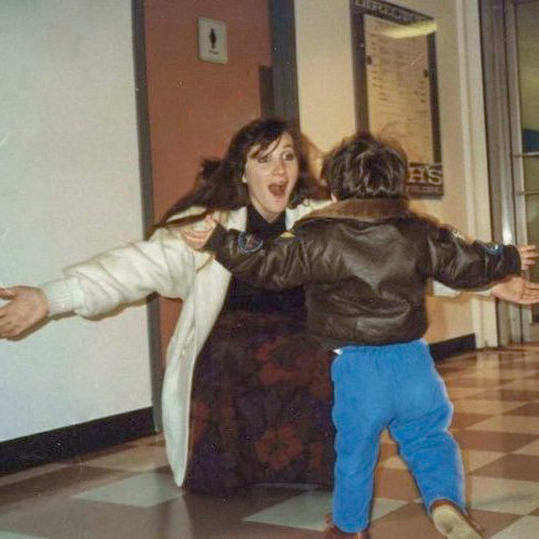 A little boy running into his mother's arms